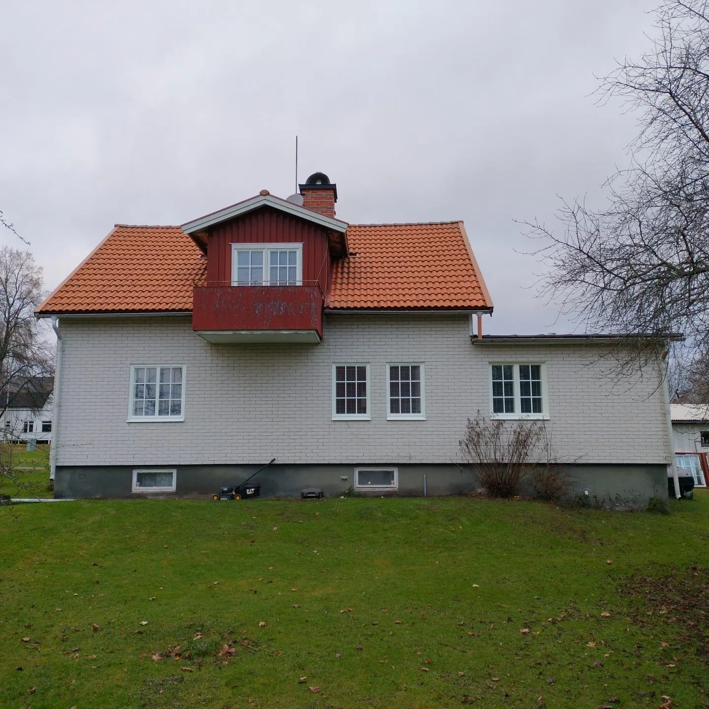 Husfasad med vita spröjsade fönster.